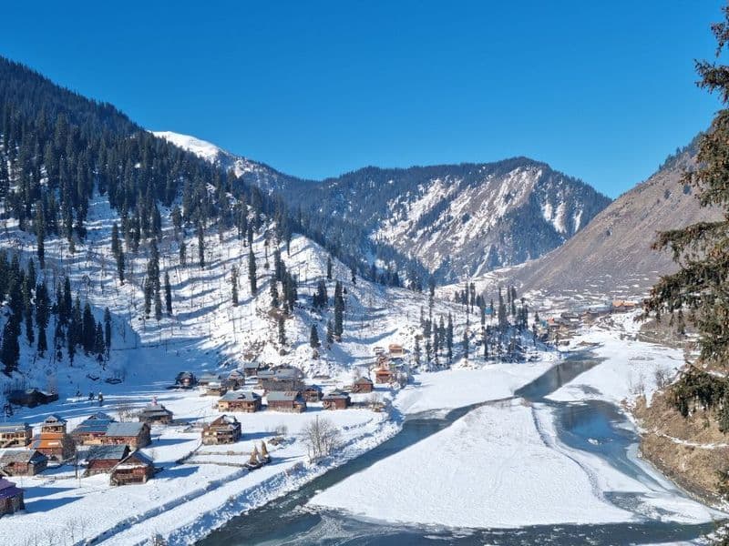 Houseboats on Dal Lake with mountains in the background